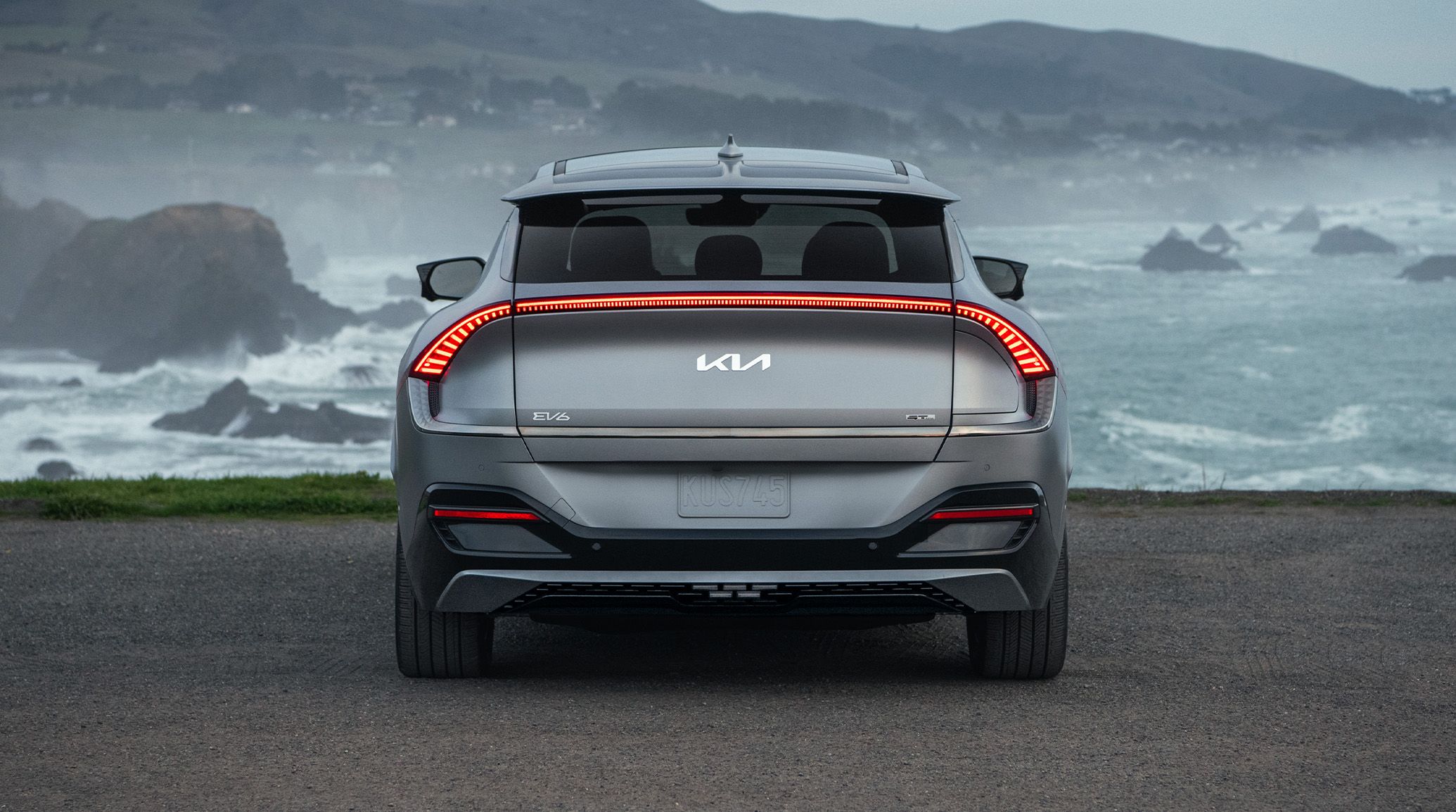 2024 Kia EV6 Parked Near The Coast-Line As Waves Crash Into The Rocks Rear-View
